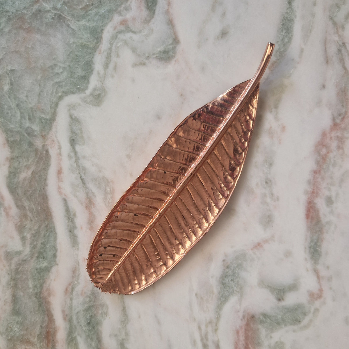 Plumeria leaf decorative object with a rose-gold coloured metallic finish and detailed veins
